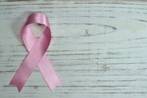 Pink Cancer ribbon on wood background